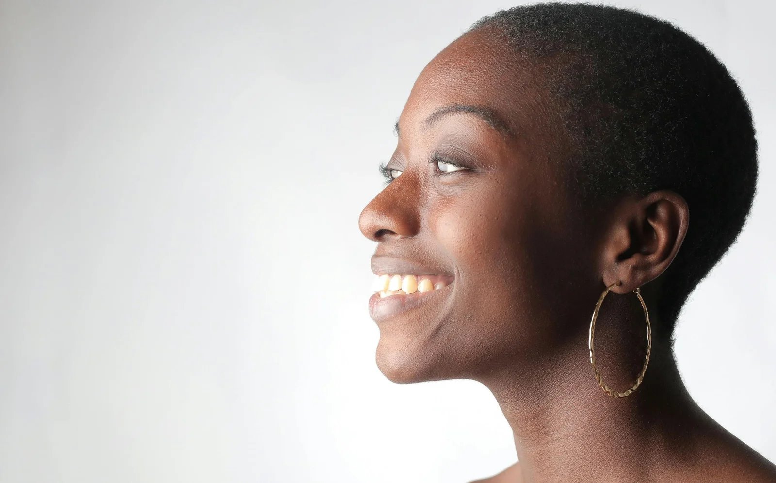Woman in profile with her ear clearly visible against a light background