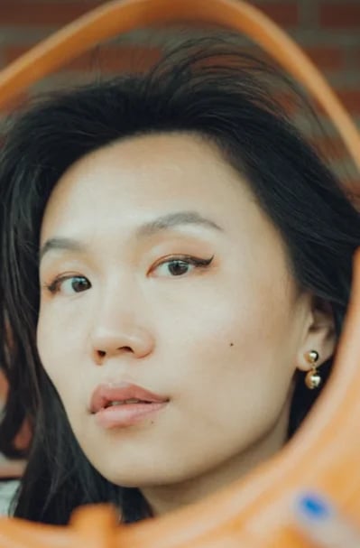 Woman examining her under-eye area in a mirror